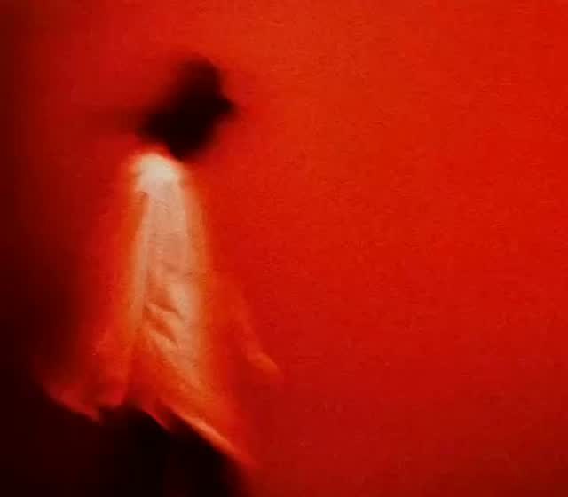 Silueta borrosa sobre fondo rojo