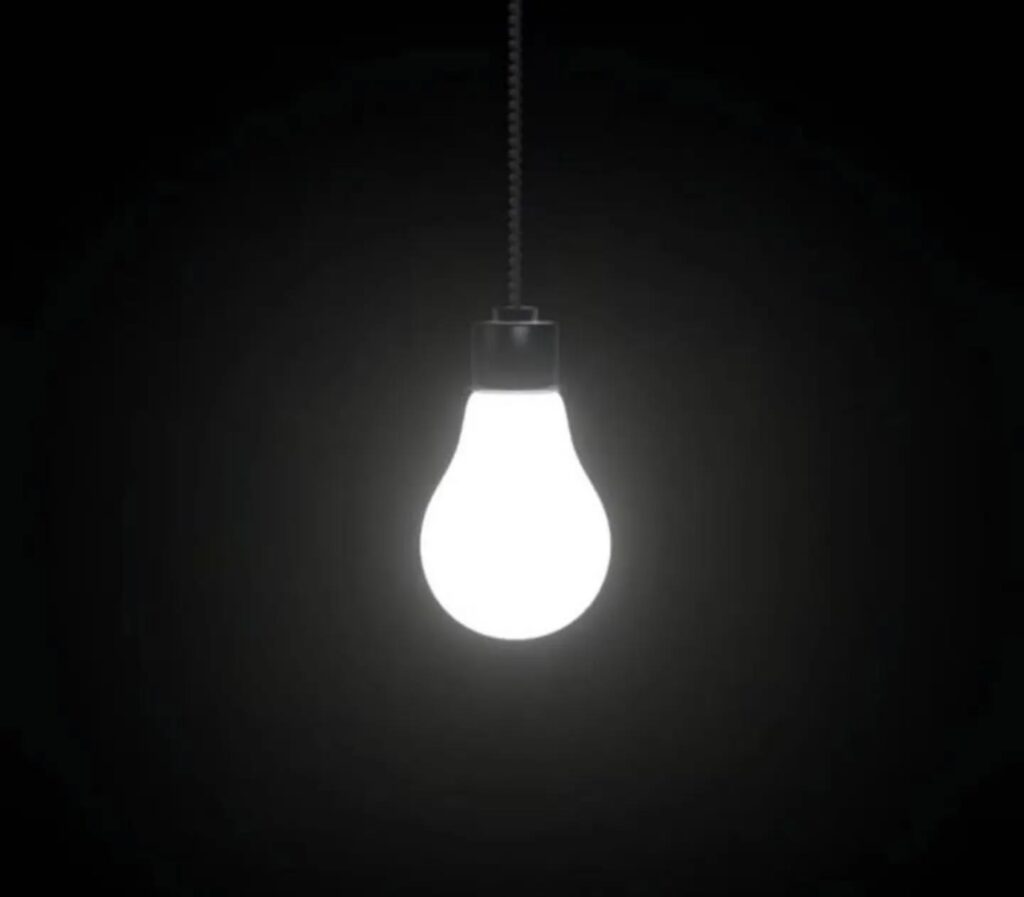 Un bombillo encendido sobre fondo negro
