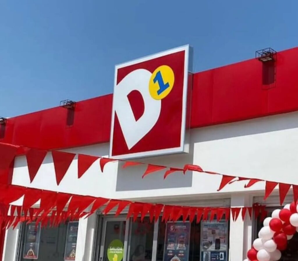 Fachada de una tienda D1 con banderines y globos rojos y blancos