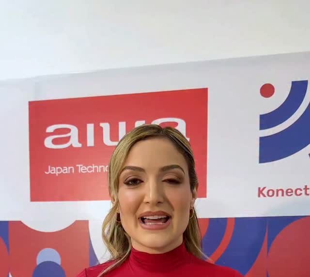 Presentadora frente al fondo de Aiwa y Konectable en la inauguración