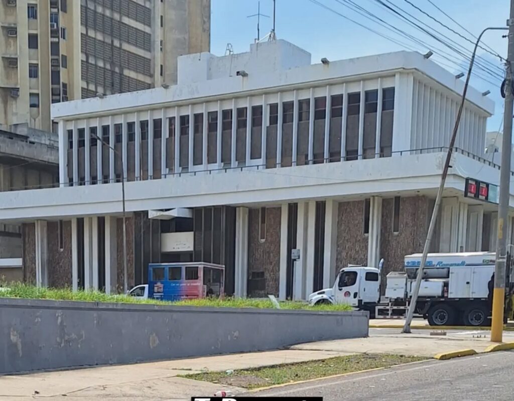 Edificio blanco de dos plantas en la avenida Bella Vista, con camiones de obra al frente